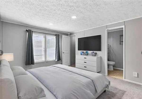 a bedroom with a large bed and a flat screen tv