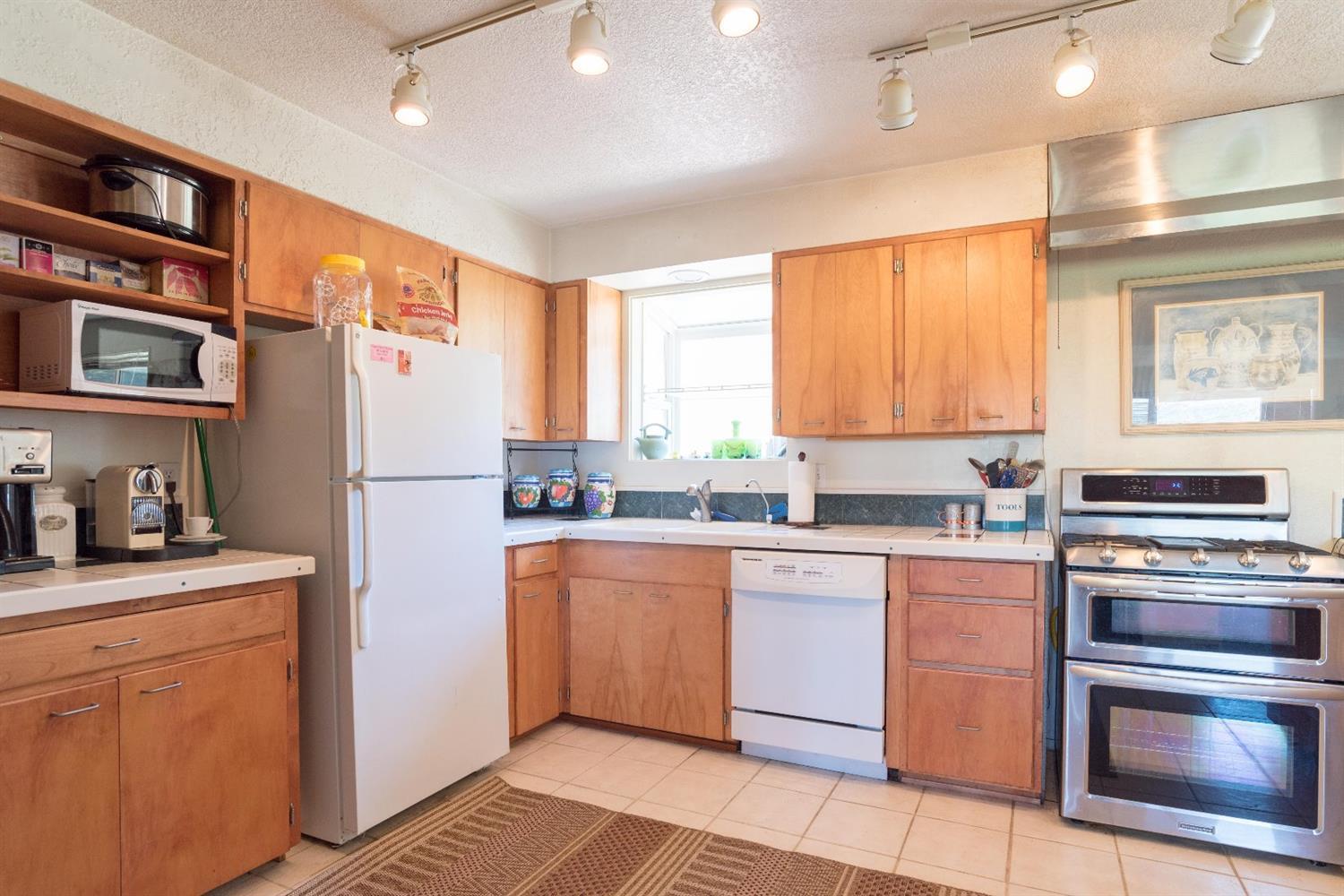 206 West Hilltop Road Talent, OR 97540 - Photo 10 of 29 a kitchen with a refrigerator a stove a sink cabinets and a dining table