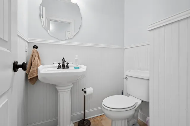 a bathroom with a sink toilet and a mirror