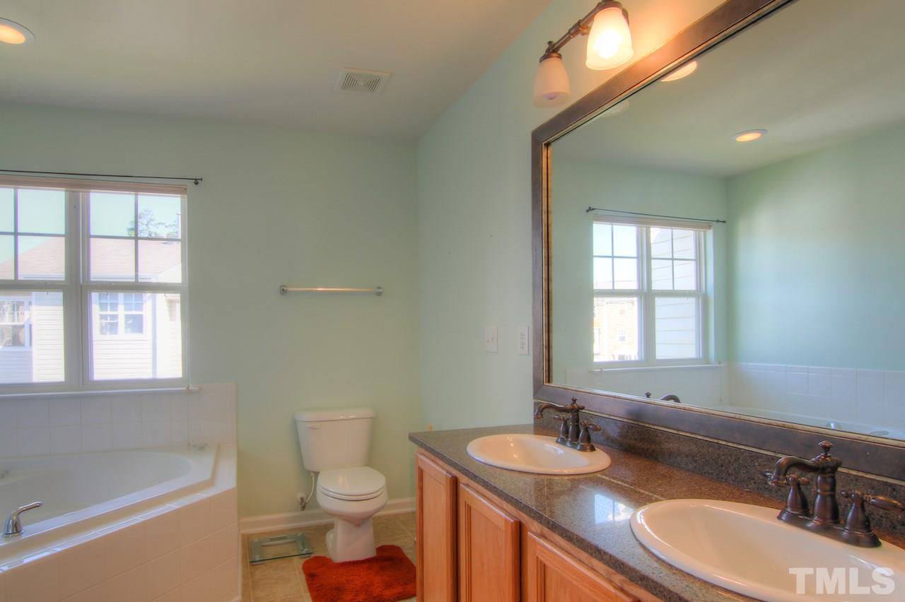 115 Darley Dale Loop Apex, NC 27502 - Photo 11 of 25 a bathroom with a sink a toilet and tub