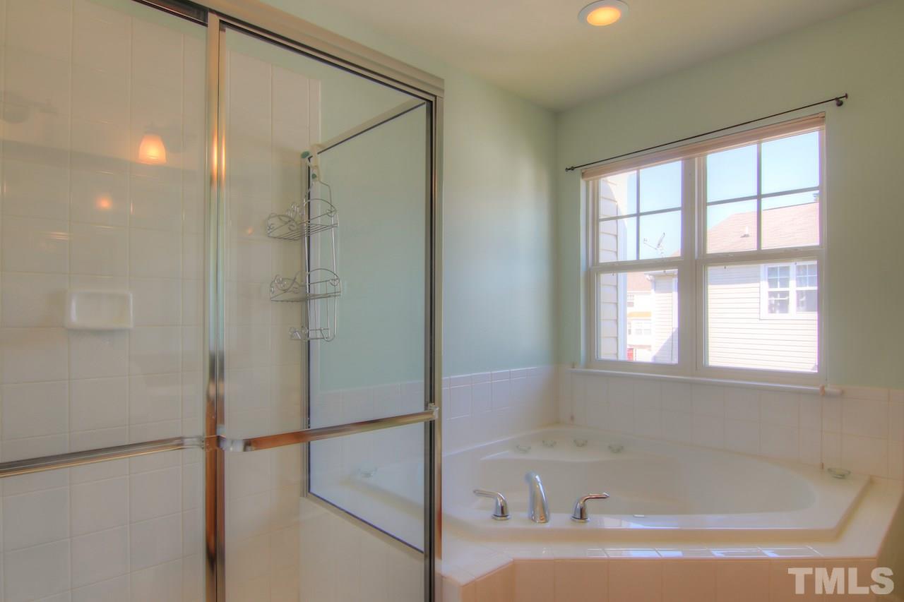 115 Darley Dale Loop Apex, NC 27502 - Photo 12 of 25 a bathroom with a bathtub and a shower