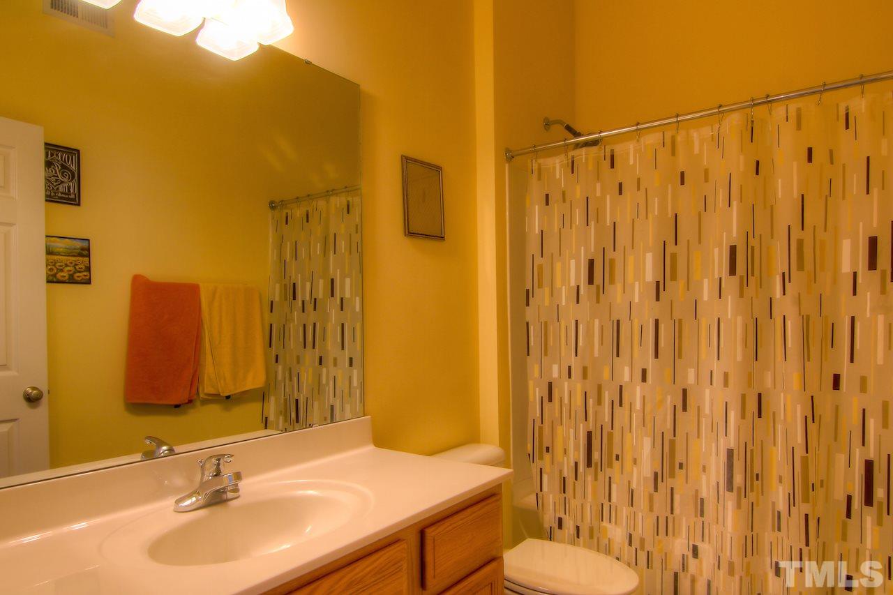 115 Darley Dale Loop Apex, NC 27502 - Photo 17 of 25 a bathroom with a sink and a mirror