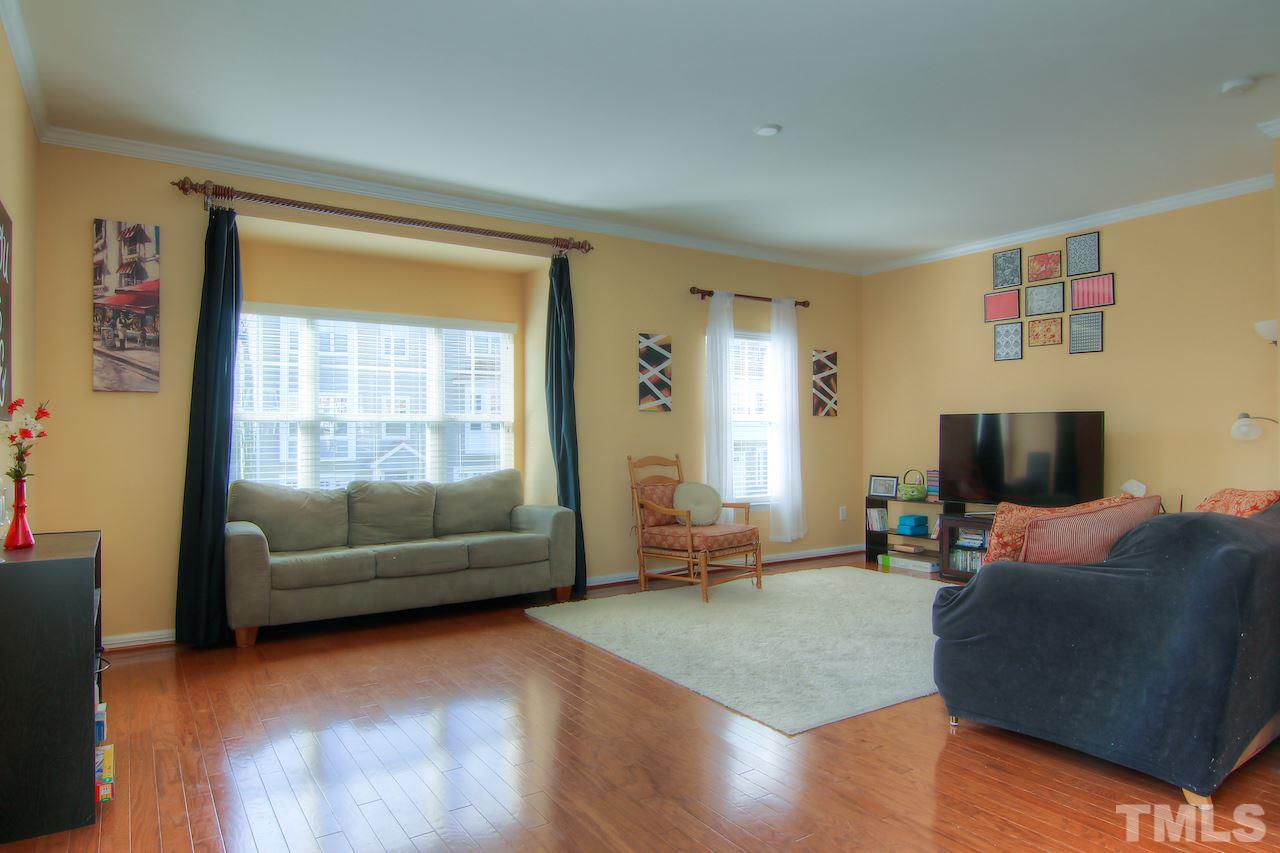 115 Darley Dale Loop Apex, NC 27502 - Photo 18 of 25 a living room with furniture and a flat screen tv
