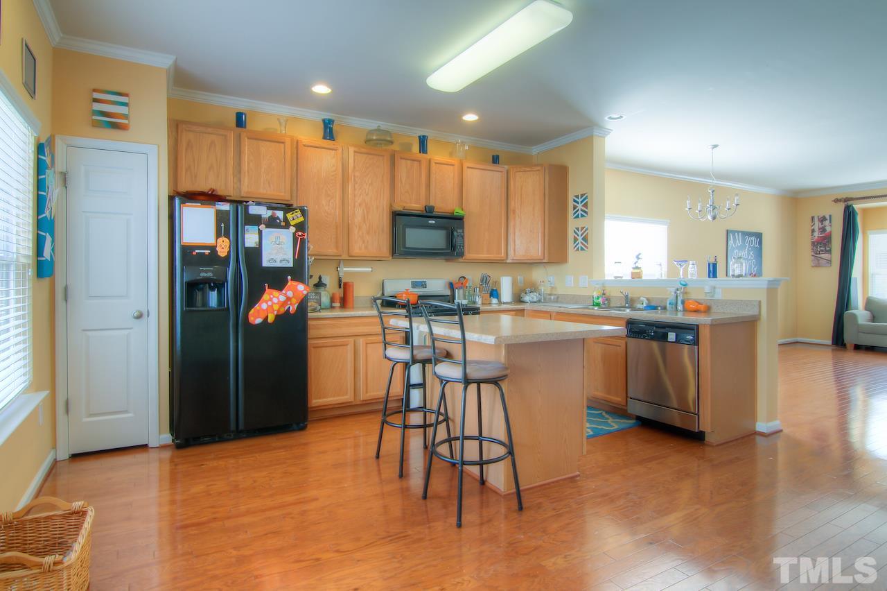 115 Darley Dale Loop Apex, NC 27502 - Photo 6 of 25 a kitchen with stainless steel appliances granite countertop a refrigerator a stove top oven a sink and dishwasher