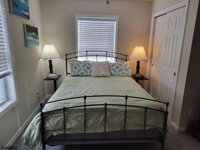 a bedroom with a bed a flat screen tv and a window