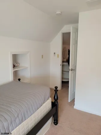 a bedroom with a bed and a view of closet