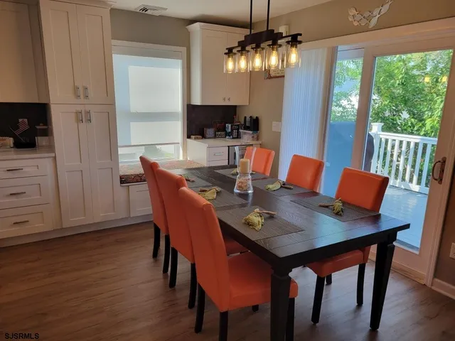 a kitchen with stainless steel appliances granite countertop a stove top oven a refrigerator a sink and dishwasher with wooden floor