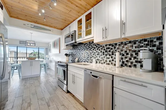 a kitchen with granite countertop white cabinets and wooden floor