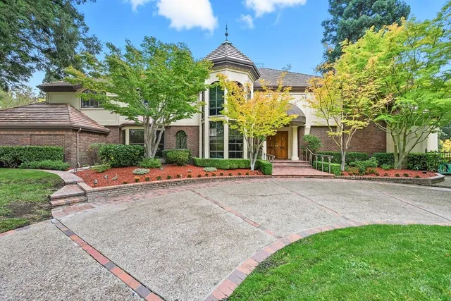 a front view of a house with a yard and trees