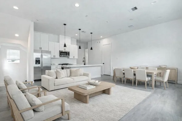 a living room with furniture white walls and kitchen view