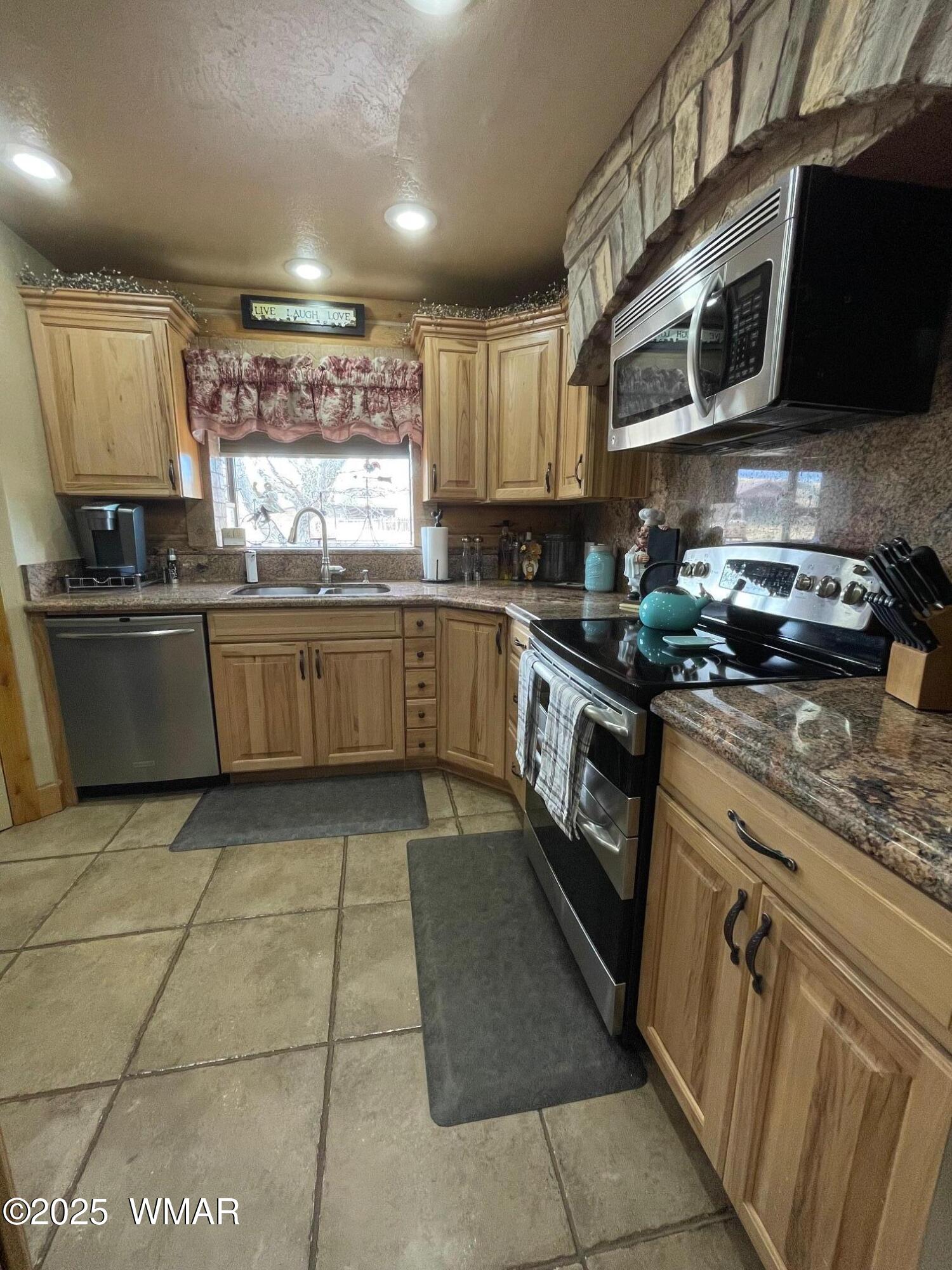 183 North Becker Lake Road Springerville, AZ 85938 - Photo 15 of 41 a kitchen with stainless steel appliances granite countertop a stove a sink and a microwave