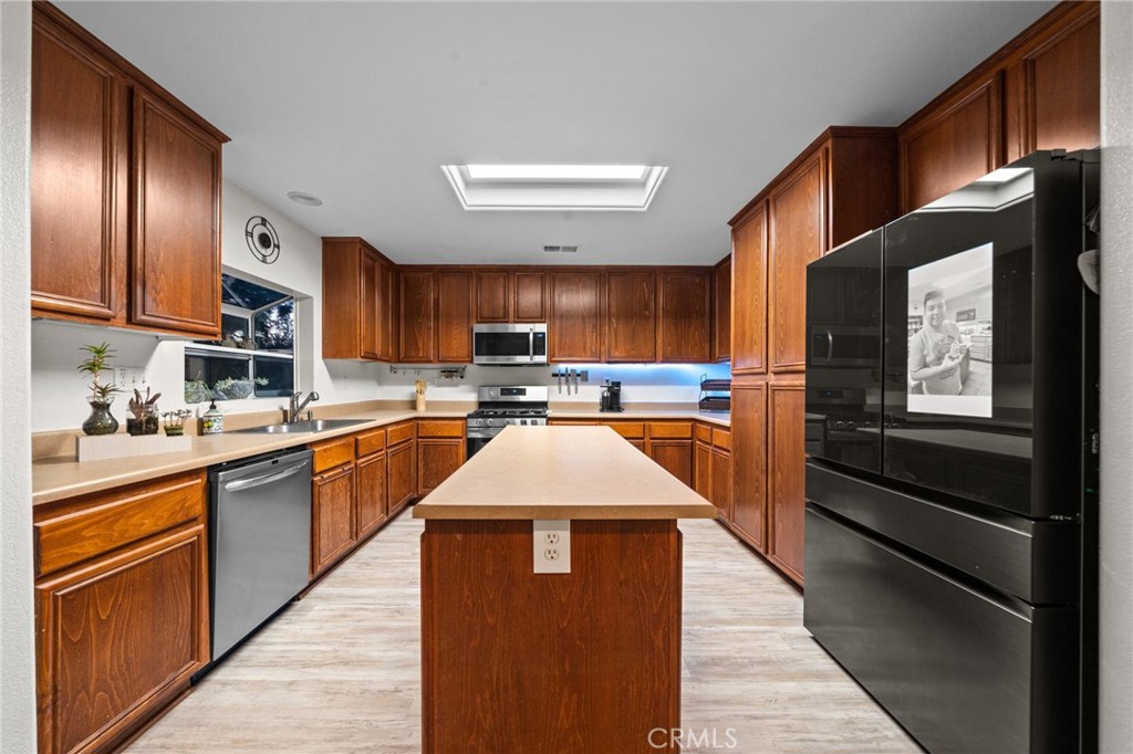 809 Classic Avenue Beaumont, CA 92223 - Photo 19 of 41 a kitchen with stainless steel appliances granite countertop wooden cabinets a stove top oven a sink and dishwasher