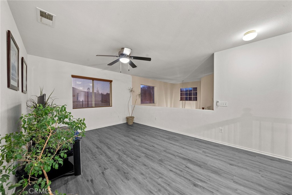809 Classic Avenue Beaumont, CA 92223 - Photo 23 of 41 a view of an empty room with a window and wooden floor