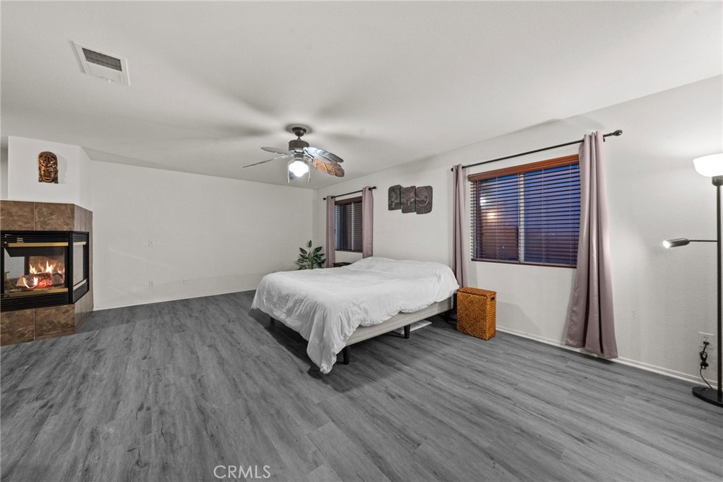 809 Classic Avenue Beaumont, CA 92223 - Photo 27 of 41 a spacious bedroom with a bed and a fireplace