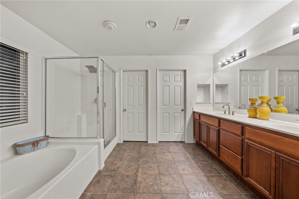 809 Classic Avenue Beaumont, CA 92223 - Photo 32 of 41 a spacious bathroom with a tub sink and mirror