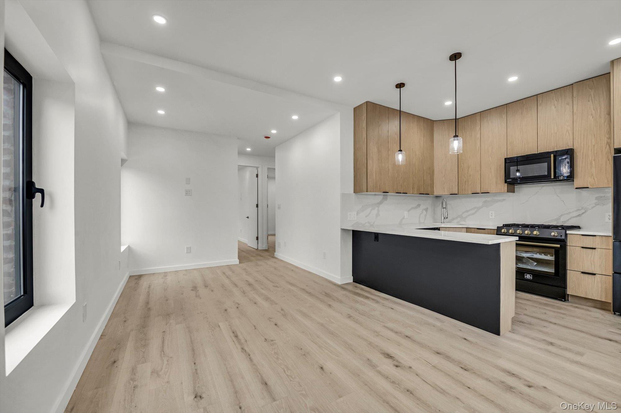 85-45 67th Road Queens, NY 11374 - Photo 16 of 28 a open kitchen with kitchen island a sink dishwasher a refrigerator and a stove with wooden floor