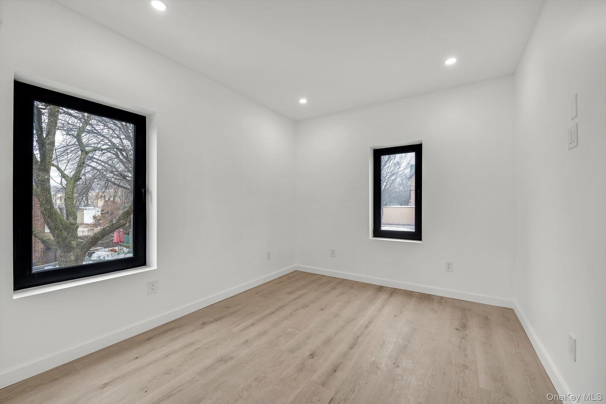 85-45 67th Road Queens, NY 11374 - Photo 19 of 28 a view of an empty room with wooden floor and a window