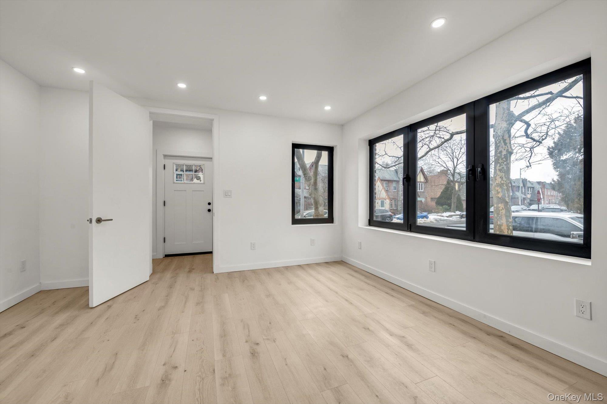 85-45 67th Road Queens, NY 11374 - Photo 2 of 28 a view of an empty room with a window and wooden floor