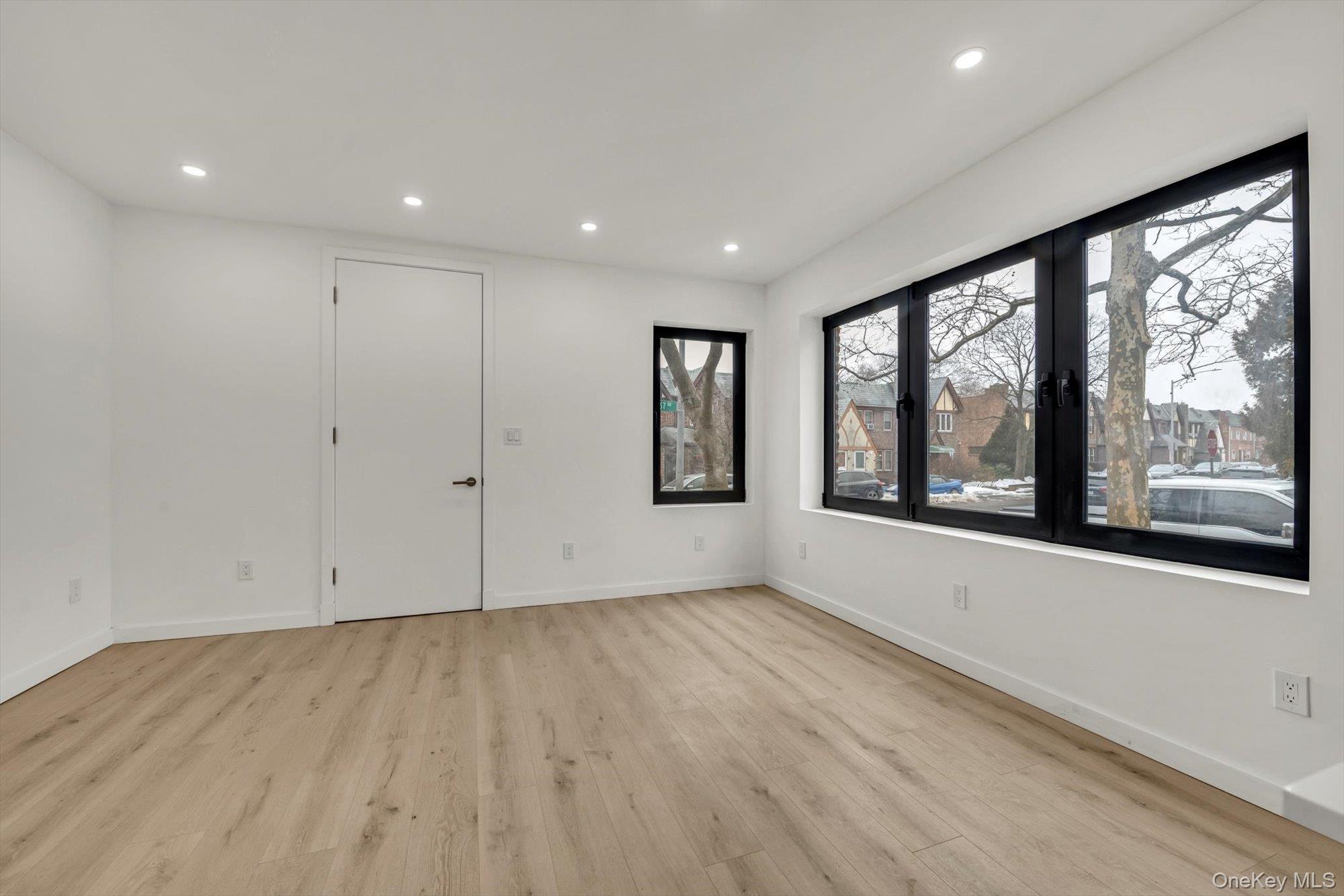85-45 67th Road Queens, NY 11374 - Photo 3 of 28 a view of an empty room with a window and hardwood floor