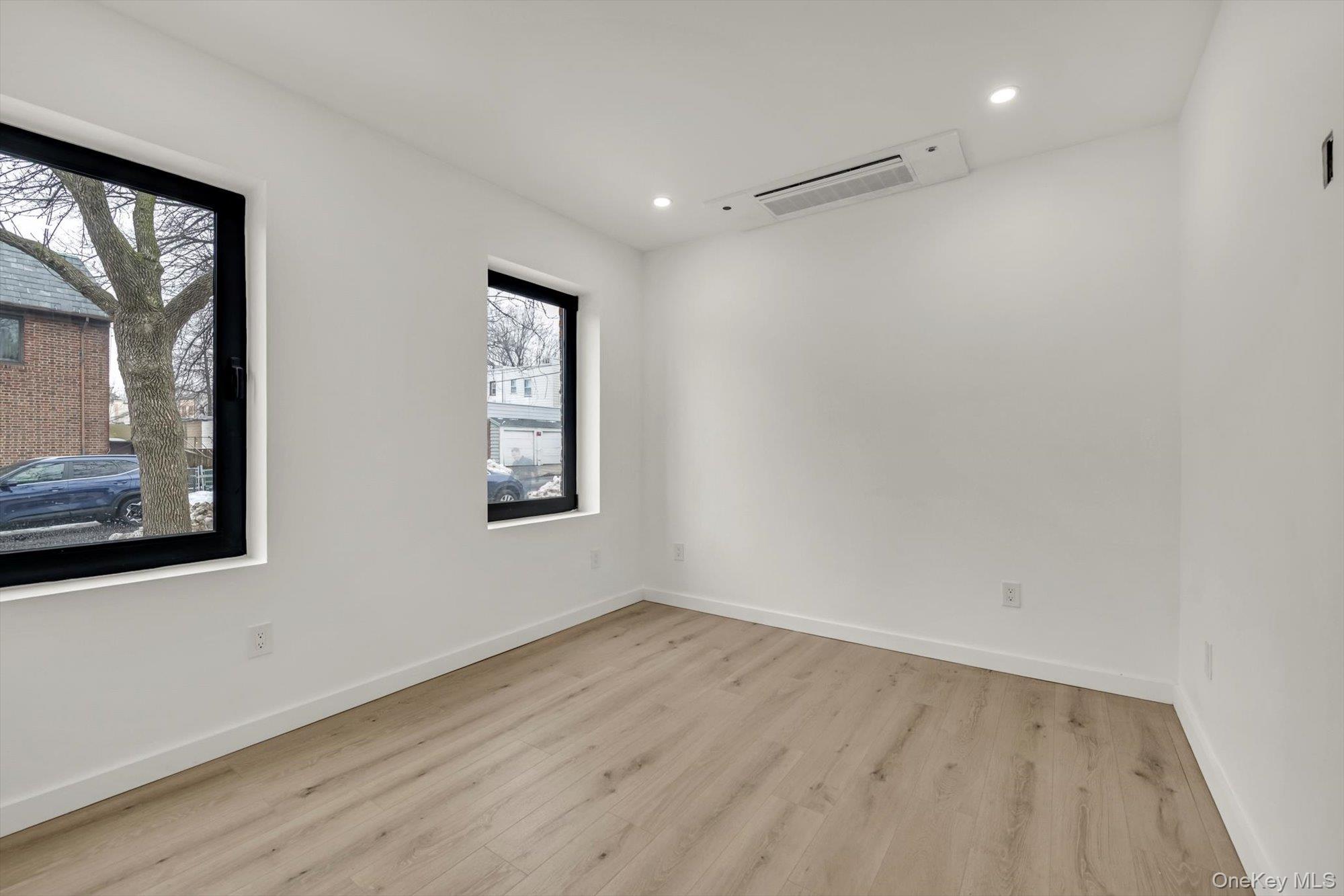 85-45 67th Road Queens, NY 11374 - Photo 7 of 28 a view of an empty room with wooden floor and a window