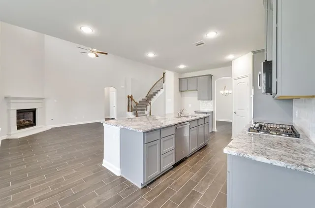 a kitchen with kitchen island sink stove and refrigerator