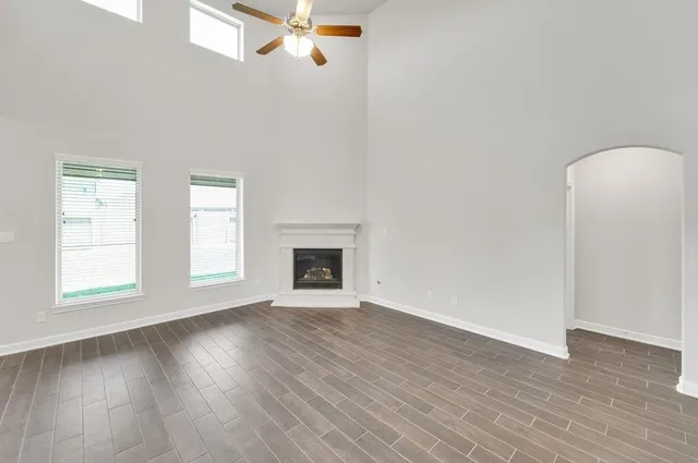 an empty room with windows and fan