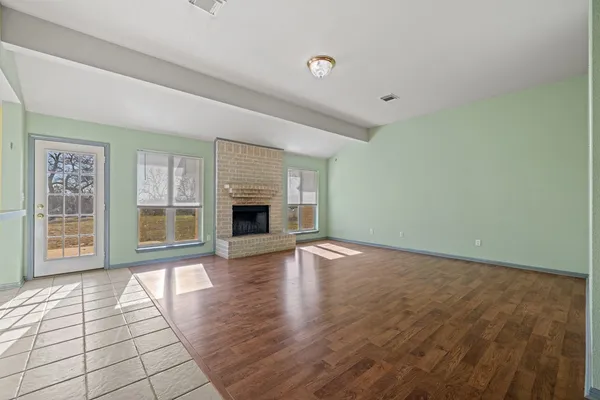 a view of empty room with wooden floor and fireplace