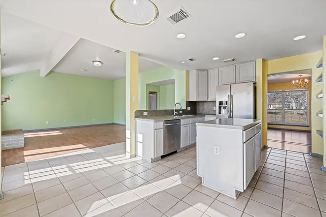 a kitchen with a sink a counter top space cabinets and stainless steel appliances