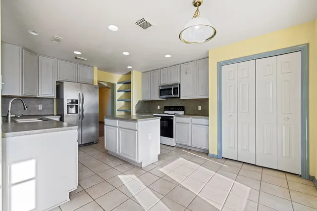 a kitchen with granite countertop cabinets stainless steel appliances and a counter space
