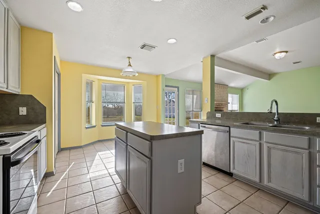 a kitchen with granite countertop a sink and a stove