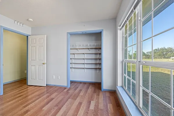 a view of a hallway with wooden floor and windows