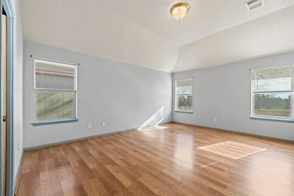 a view of an empty room with window and closet area