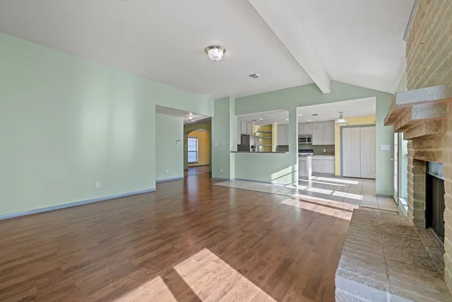 a view of empty room with wooden floor and fireplace