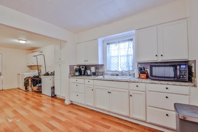a kitchen with granite countertop white cabinets and white appliances