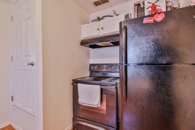 a kitchen with a refrigerator and a stove top oven