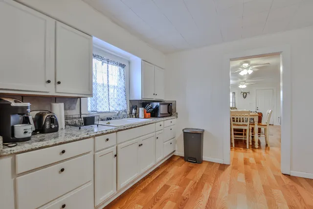 a kitchen with granite countertop white cabinets and white appliances