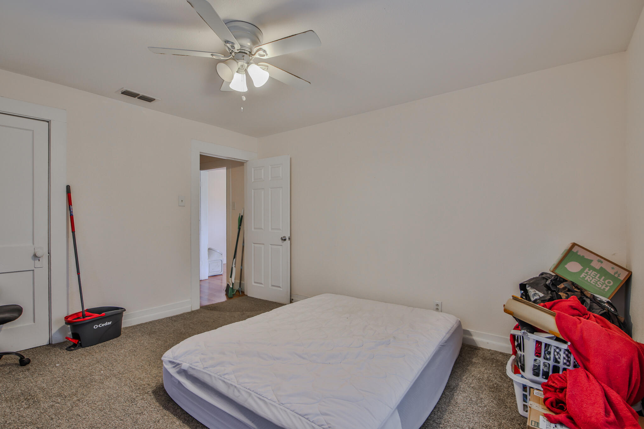 805 South 4th Street Slaton, TX 79364 - Photo 9 of 28 a bedroom with a bed and a chandelier