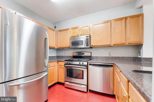 a kitchen with stainless steel appliances granite countertop a stove a refrigerator and a microwave