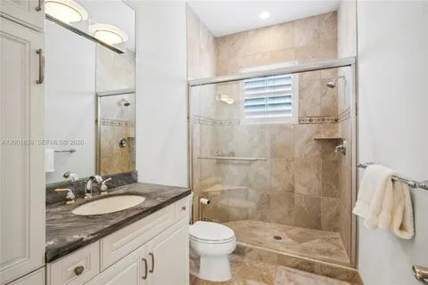 a bathroom with a granite countertop sink toilet and shower