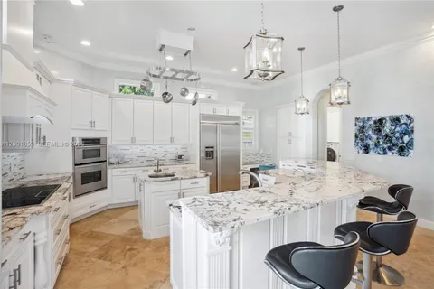 a kitchen with stainless steel appliances kitchen island granite countertop a sink and cabinets