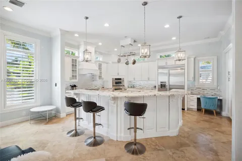 a kitchen with kitchen island granite countertop a table and chairs in it