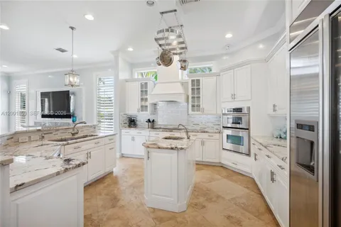 a large white kitchen with a refrigerator a stove top oven a sink and dishwasher