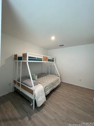 a bed sitting in a room next to a lamp