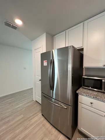 a metallic refrigerator freezer sitting in a kitchen