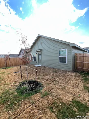 a backyard of a house with table and chairs