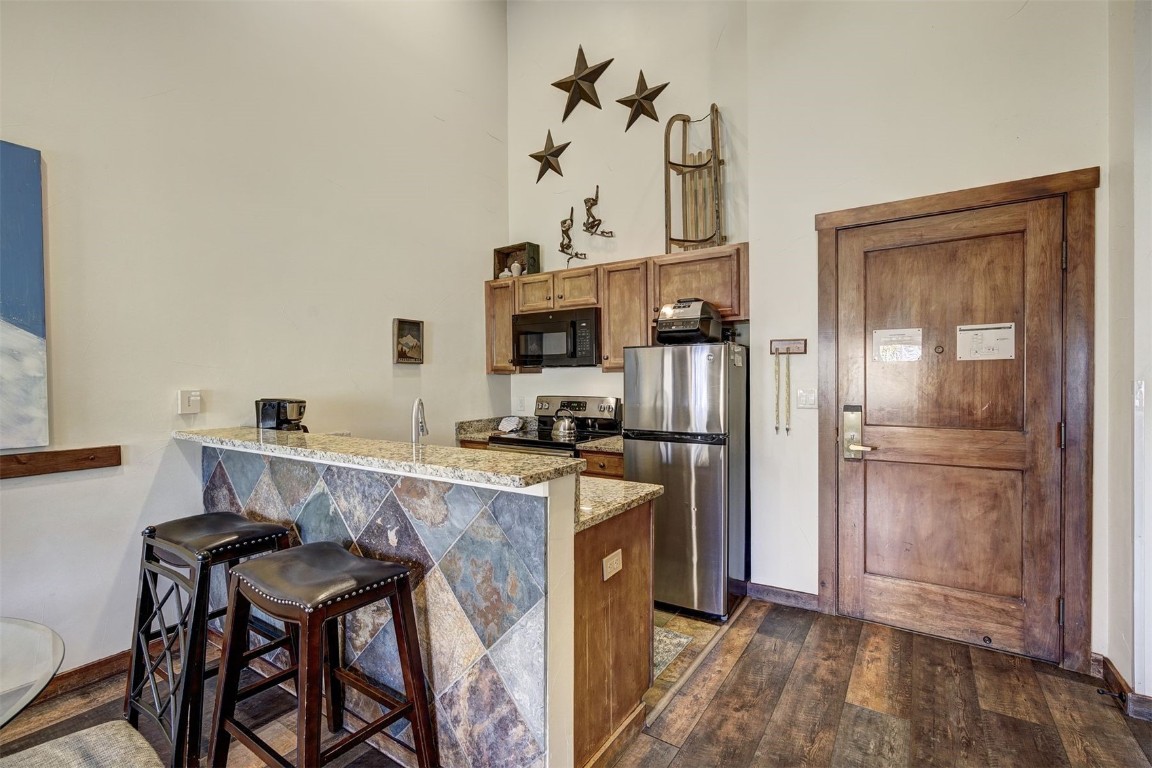 91 River Run Road, Unit 8137 Keystone, CO 80435 - Photo 5 of 37 a kitchen with a refrigerator a stove and a sink with wooden floor