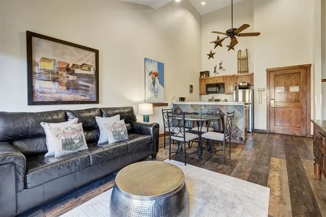 a living room with furniture a dining table and a chandelier