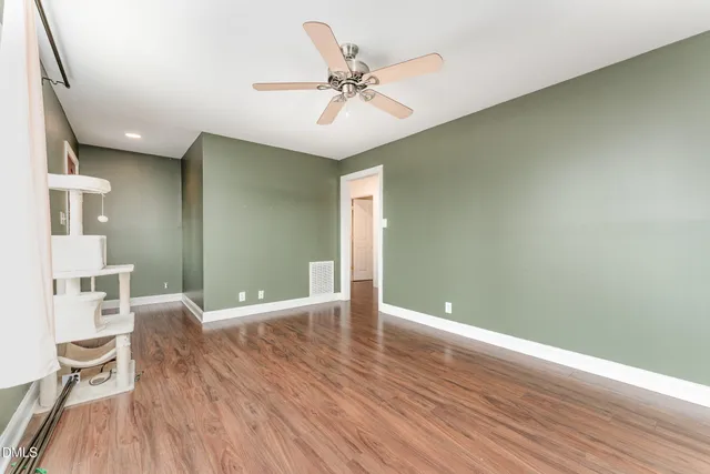 a kitchen with stainless steel appliances granite countertop a stove a sink dishwasher a microwave oven and white cabinets with wooden floor