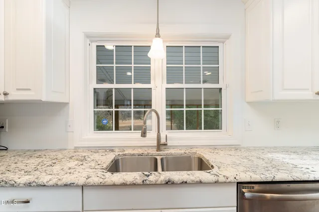 a bathroom with a granite countertop toilet sink and mirror