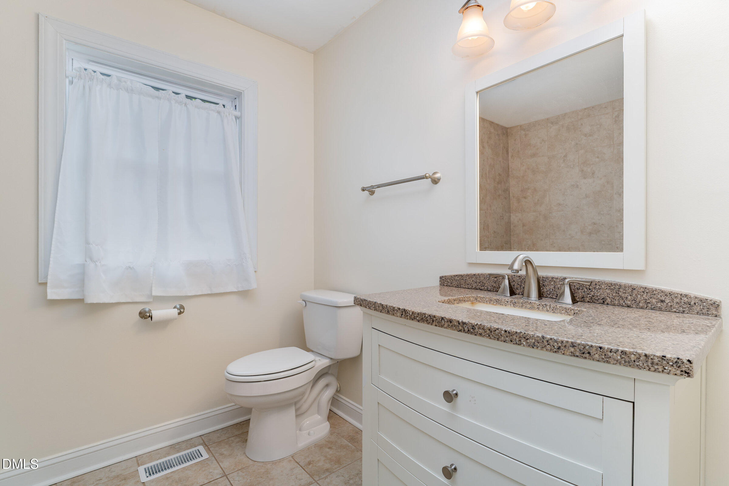 4159 Princeton Kenly Road Kenly, NC 27542 - Photo 28 of 37 a bathroom with a granite countertop toilet sink and mirror